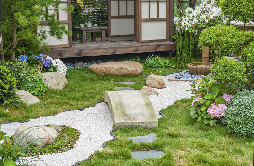 Jardin japonais avec pierres, cailloux et un petit pont.