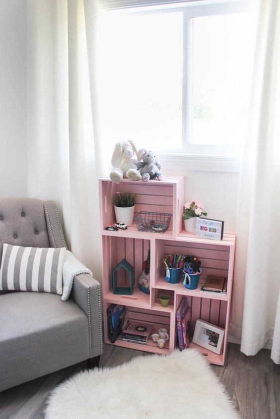 Petit meuble pour enfant avec des caisses roses.